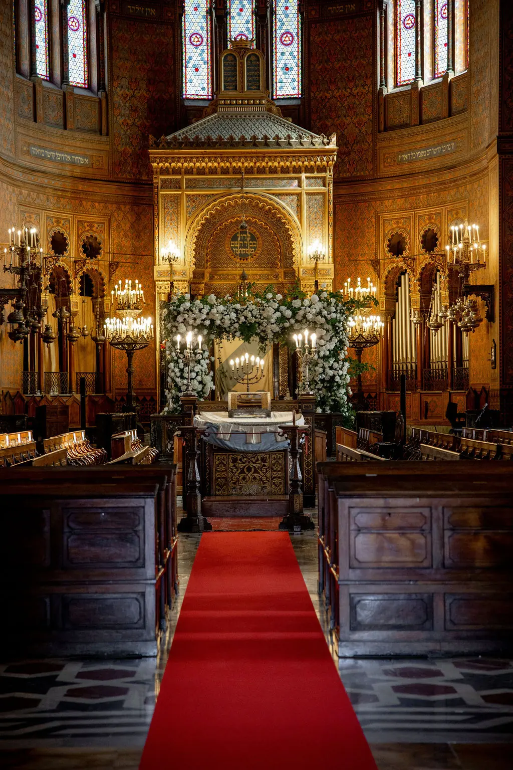 Intérieur de synagogue, tapis rouge menant à la houppa