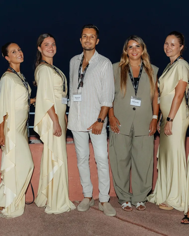L’équipe en tenues crème sur une terrasse, face à la mer